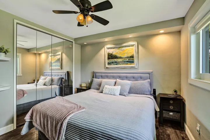 Private primary suite with custom built-in closet, luxury vinyl plank flooring, abundant natural light, and beautifully remodeled ensuite bath.
