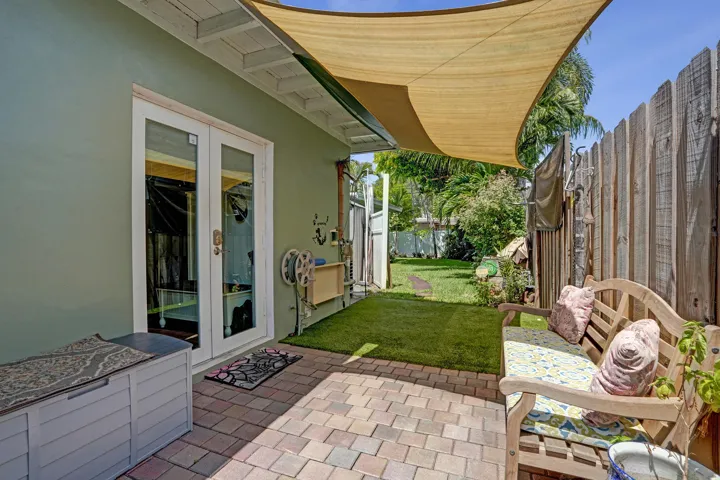 Private side yard featuring pet-friendly turf and a convenient outdoor wash station—perfect for rinsing off pets, kids, or after gardening.