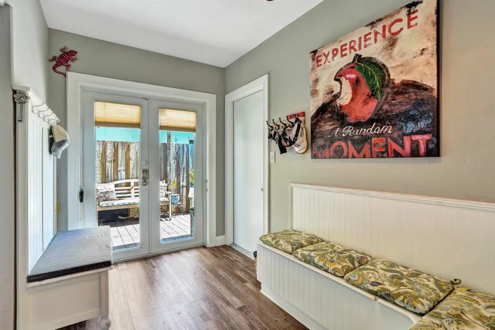 Charming breakfast nook with built-in banquet seating, additional hidden storage, and views of the tropical patio.