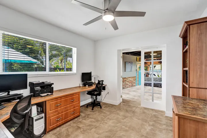 Flexible office or fourth bedroom featuring custom built-in cabinetry, desk, bookshelves, ample storage, and an original closet.