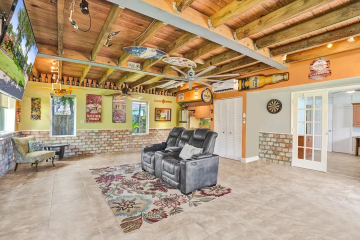Extraordinary bonus room with tongue-and-groove stained wood ceiling, Chicago brick accents, wet kitchenette, ARAN Italian cabinetry, granite countertops, TV bar, dedicated mini-split A/C, and endless possibilities for media, fitness, or guest accommodations.