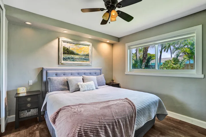 Private primary suite with custom built-in closet, luxury vinyl plank flooring, abundant natural light, and beautifully remodeled ensuite bath.