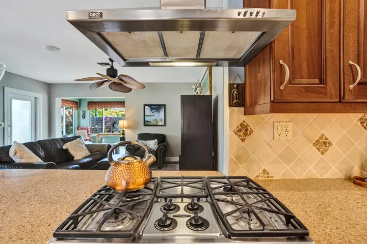 NKBA-designed chef's kitchen featuring ARAN Italian cabinetry, Silestone quartz countertops from Spain, KitchenAid Professional Series stainless appliances, natural gas cooktop, Bosch paneled dishwasher, walk-in pantry, and spacious eat-in peninsula.