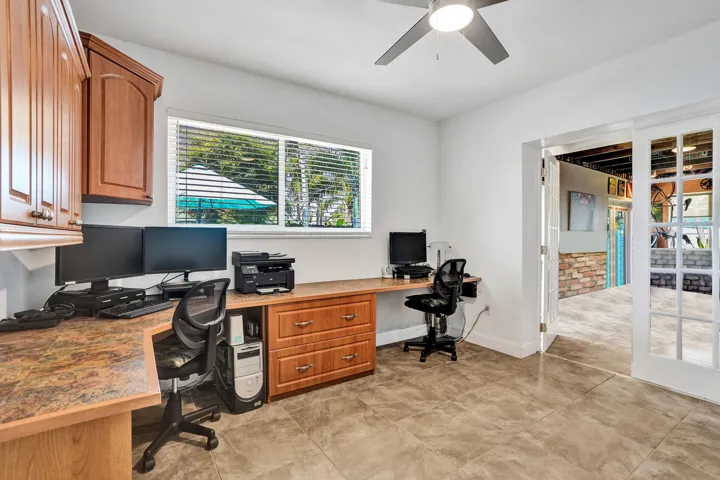 Flexible office or fourth bedroom featuring custom built-in cabinetry, desk, bookshelves, ample storage, and an original closet.