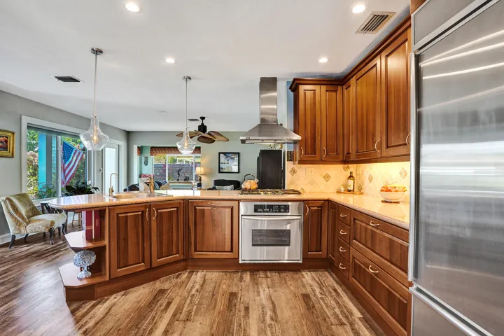 NKBA-designed chef's kitchen featuring ARAN Italian cabinetry, Silestone quartz countertops from Spain, KitchenAid Professional Series stainless appliances, natural gas cooktop, Bosch paneled dishwasher, walk-in pantry, and spacious eat-in peninsula.
