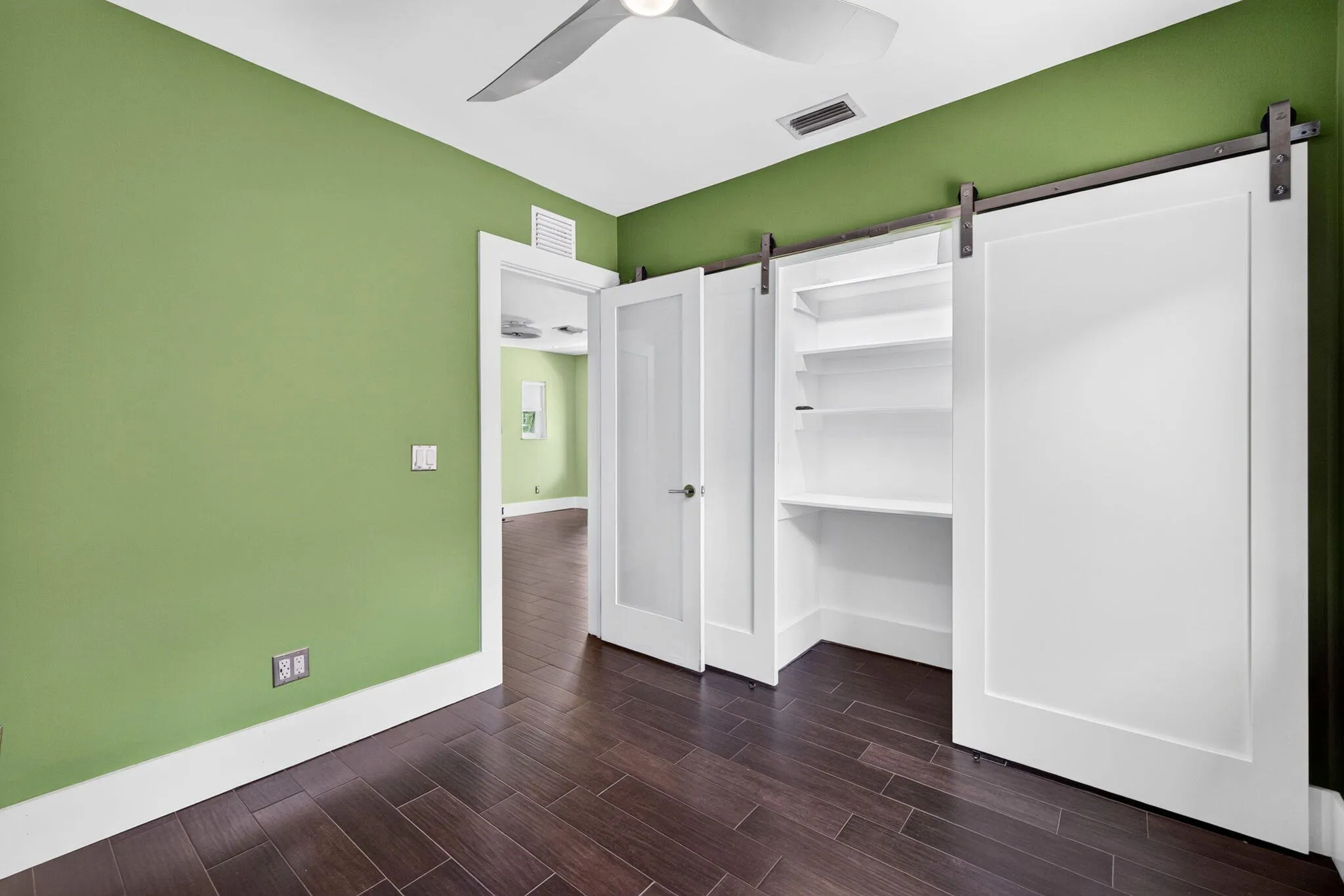 Lovely barn door on closet with builtin shelves