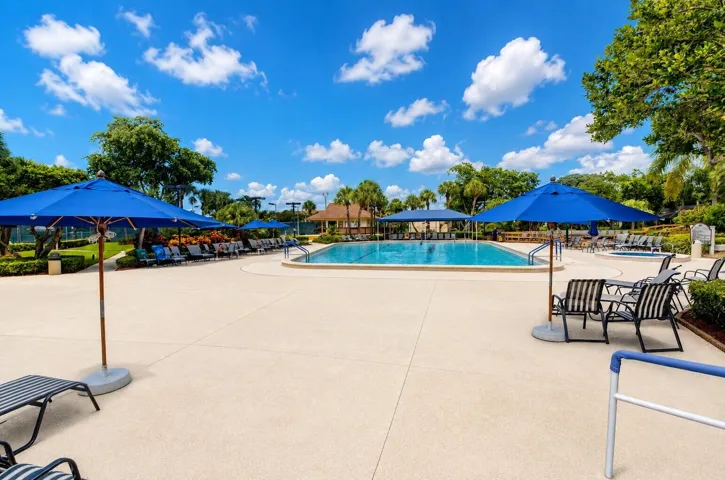 Relax poolside with expansive sundeck, umbrellas, and tropical surroundings.