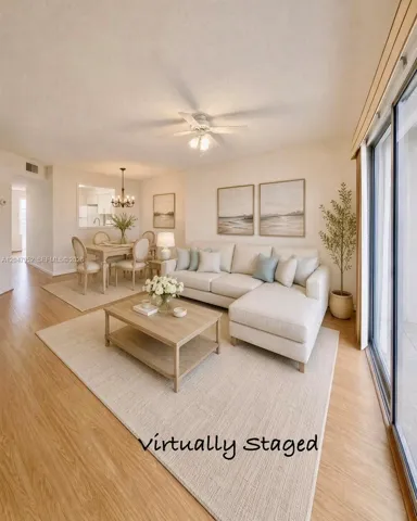 Wood-finish flooring, ceiling fan with integrated lighting, pass-through window, and sliding glass patio doors