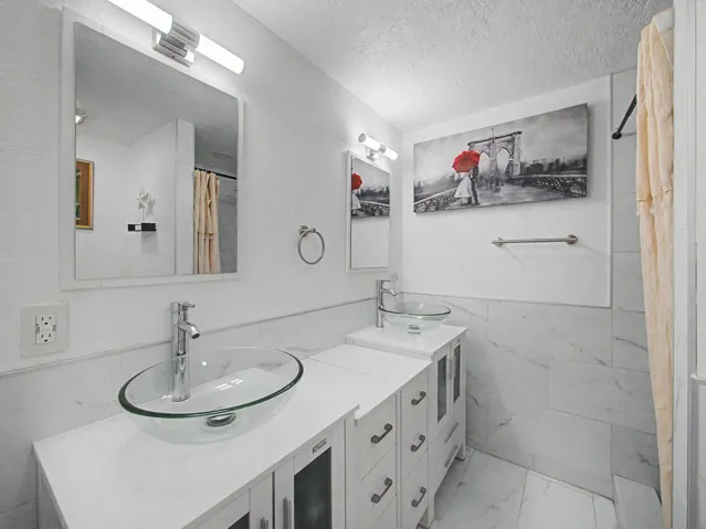 Wood-finish Laminate flooring throughout, featuring a ceiling fan, mirrored closet doors, and light-colored walls