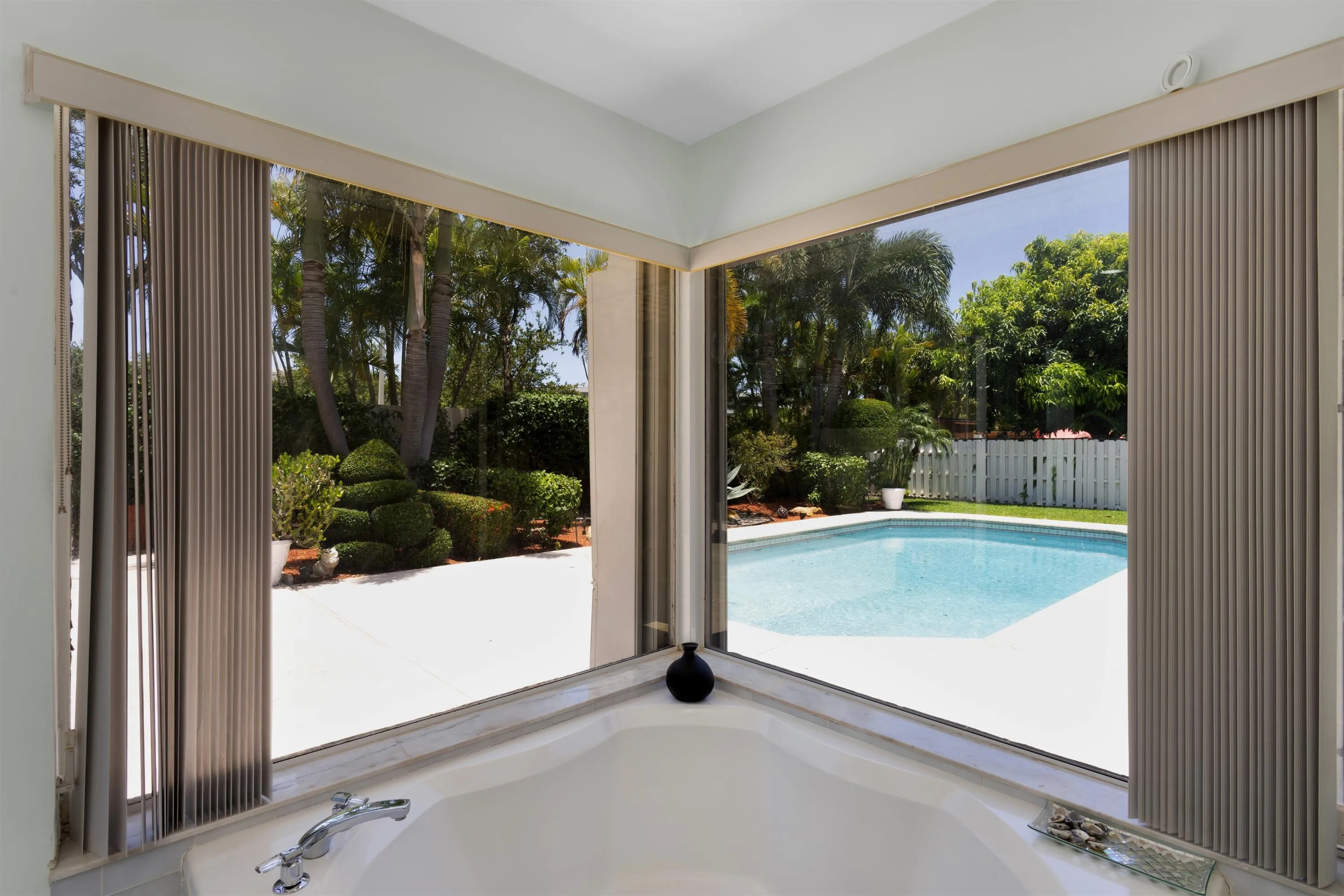 corner soaking tub overlooking the pool
