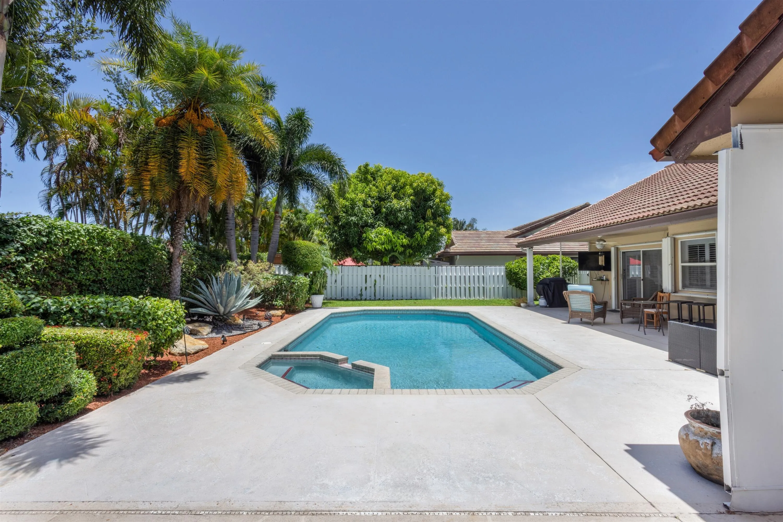 expansive backyard patio fully fenced with tropical landscaping
