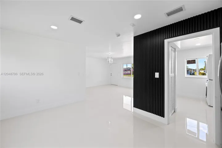 View of the main entrance door and living area from the kitchen.