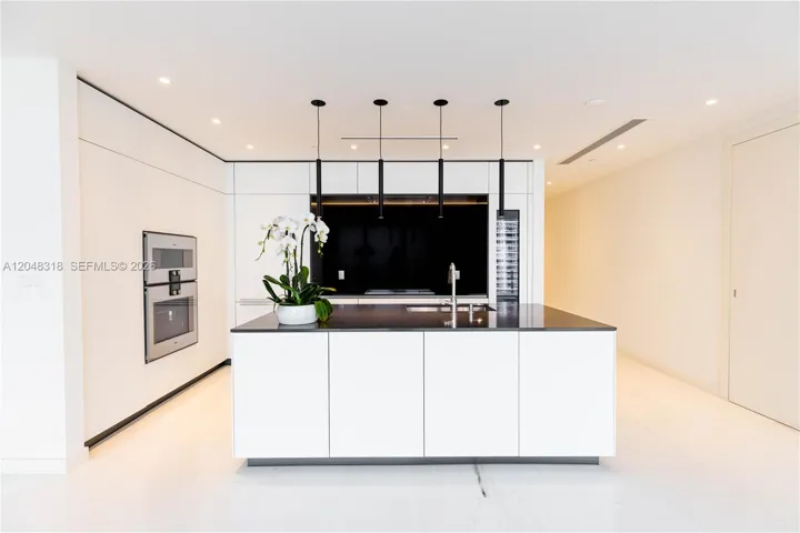 an open chef’s kitchen with custom Bulthaup cabinetry and top-of-the-line Gaggenau appliances is complemented by solid-core Bertolotto doors and imported Thassos.