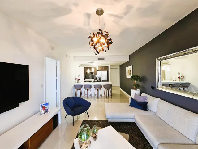 Spacious living area featuring polished tile flooring and a distinctive contemporary ceiling fixture
