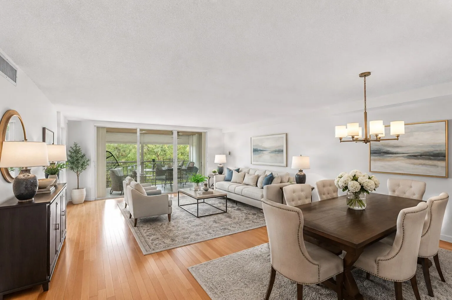 Virtually Staged expansive living and dining area showcases rich cherry hardwood flooring and an open, inviting layout that flows seamlessly to the screened balcony overlooking the golf course.