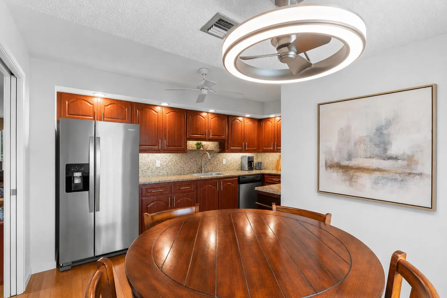Rich cabinetry, granite countertops, and newer stainless steel appliances create a kitchen that's equally suited for entertaining and everyday meals.