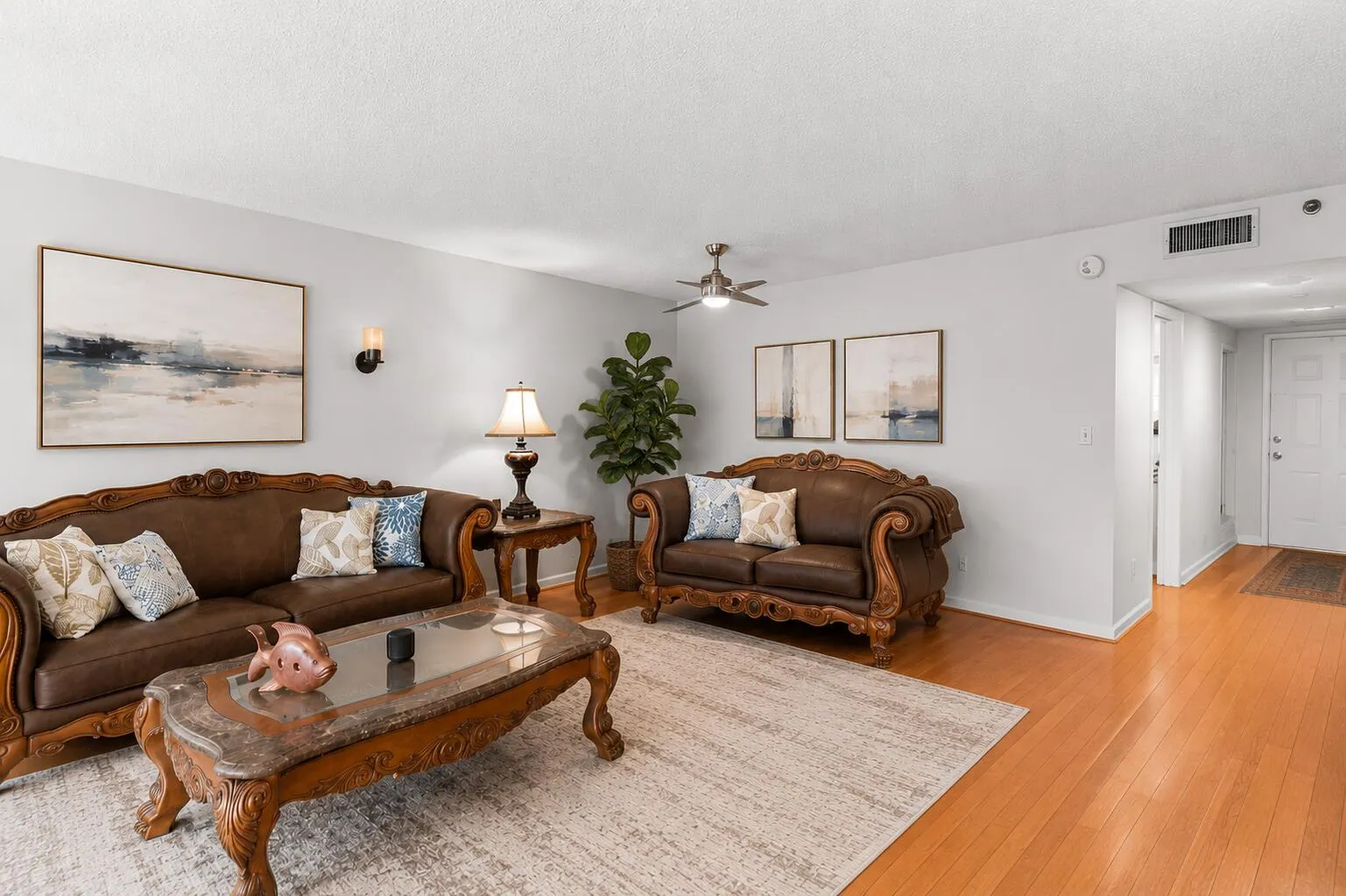 Filled with natural light, the expansive great room offers generous living and dining spaces accented by beautiful cherry hardwood flooring. Sliding glass doors open to a screened balcony overlooking the golf course, creating the perfect setting to relax, entertain, or simply enjoy the view.