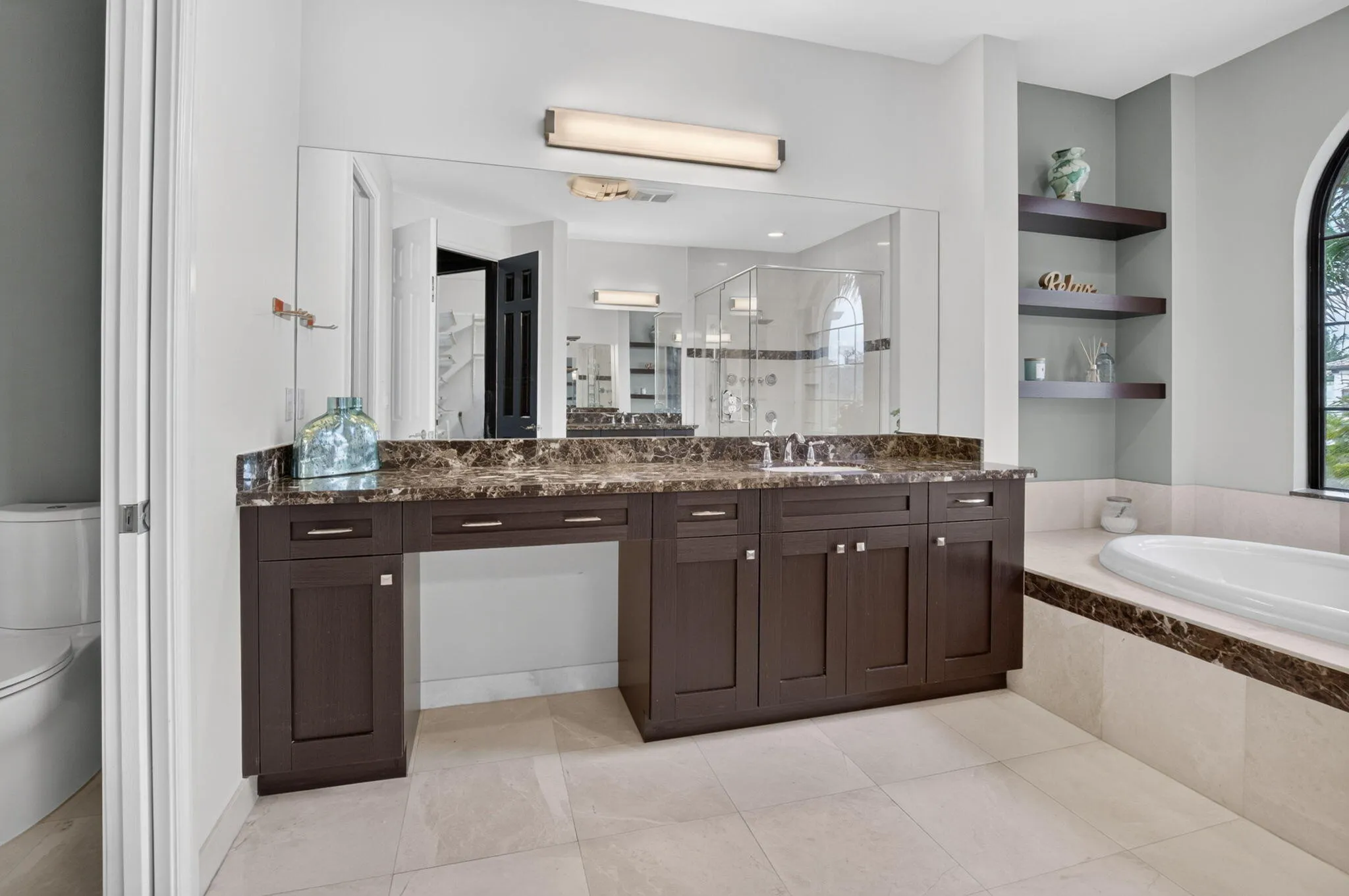Dual vanity with an expansive countertop, integrated undermount sinks, and dark wood cabinetry