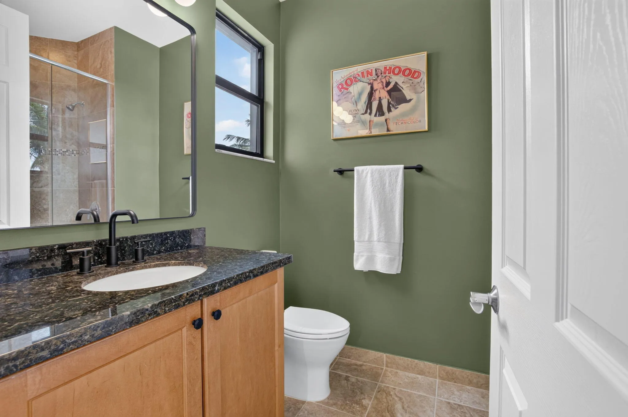 Bathroom vanity with a dark granite countertop, undermount sink, and matte black fixtures