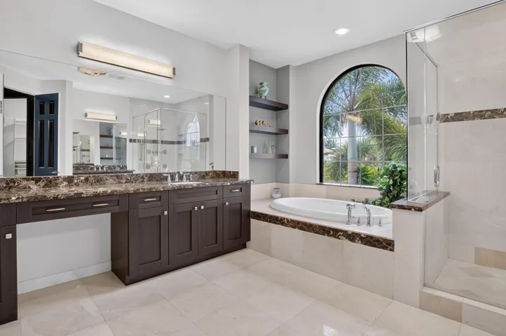 Bathroom featuring a built-in soaking tub beneath an arched window