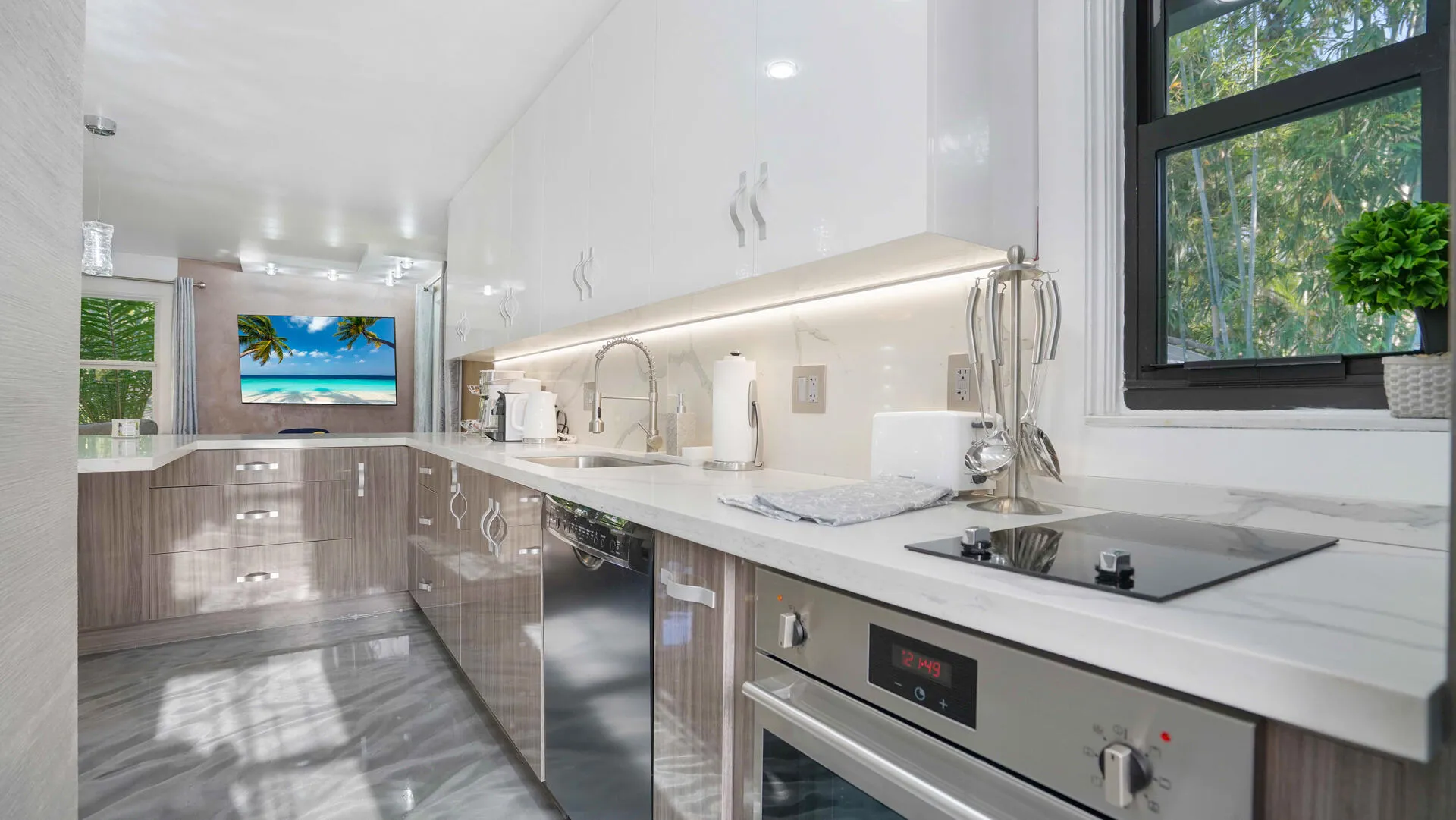 Contemporary kitchen featuring white high-gloss upper cabinetry and wood-finish lower cabinetry, complemented by a stone countertop with an integrated sink and an induction cooktop