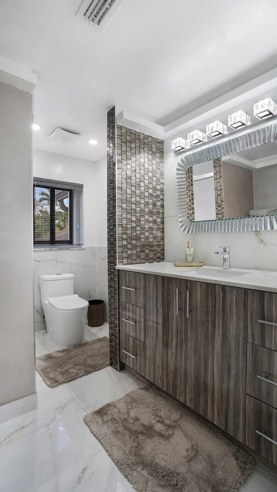 Contemporary vanity with wood-grain cabinetry, a white countertop, and an undermount sink