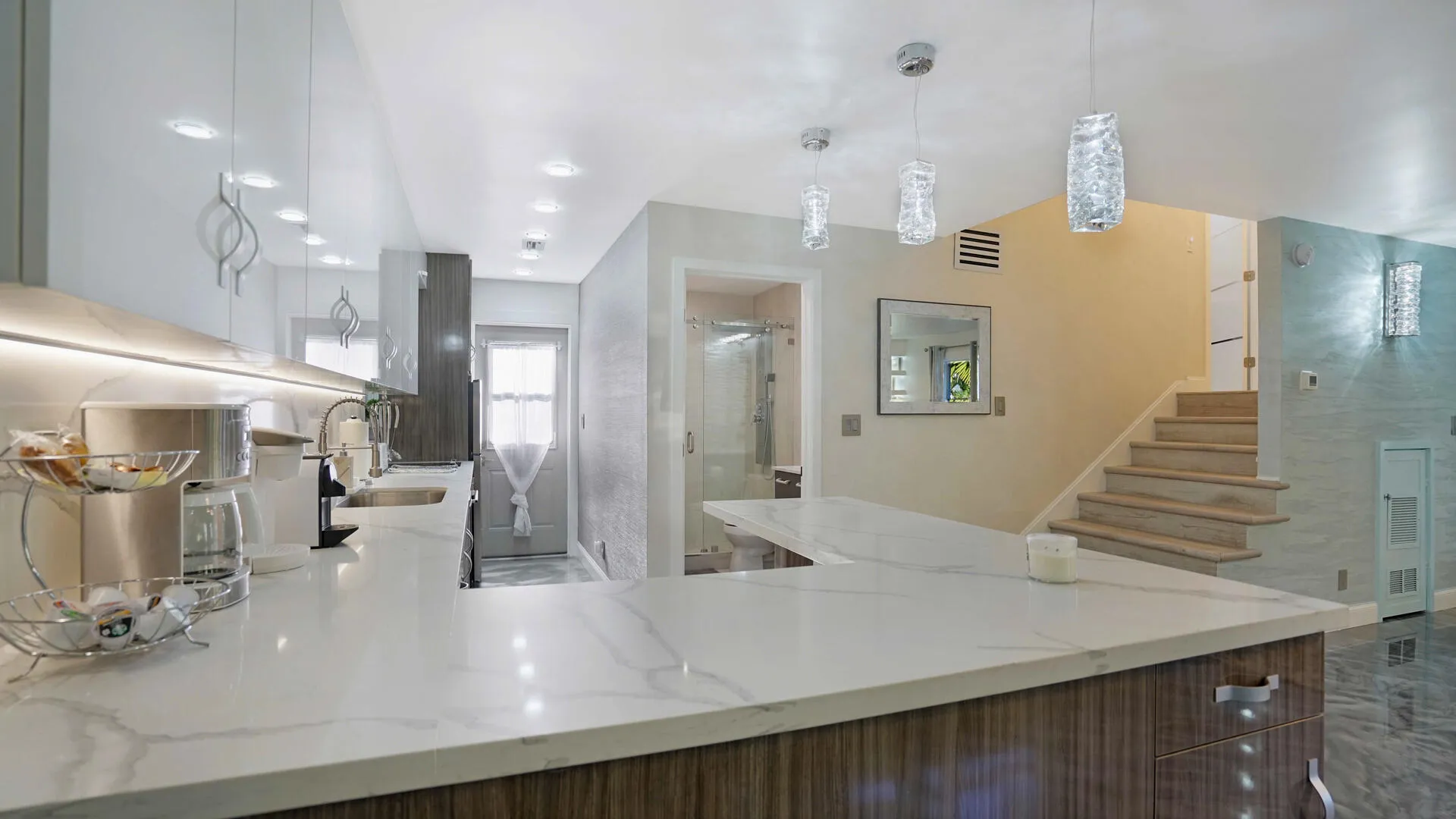 Expansive kitchen island featuring a light-toned countertop, integrated sink, and wood-finish cabinetry