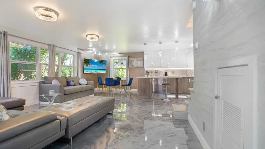 Open-concept living area featuring reflective flooring, recessed lighting, and multiple windows