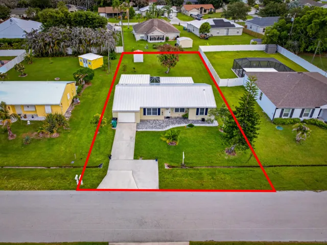 Aerial perspective showcasing a single-story residence with a metal roof and an attached garage