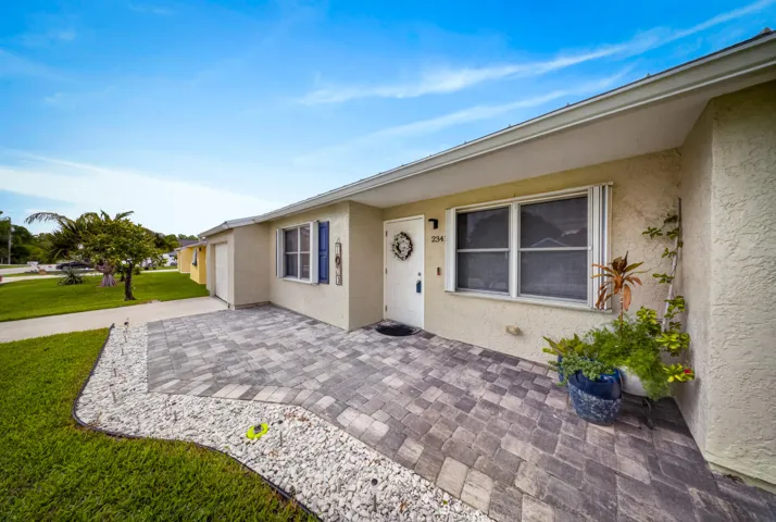 Welcoming front entry featuring a paver walkway and patio area