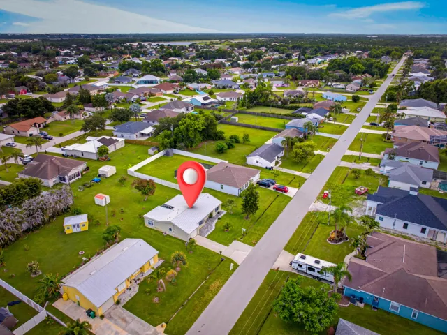 Aerial perspective of a neighborhood featuring single-story residences with diverse rooflines and varying exterior finishes