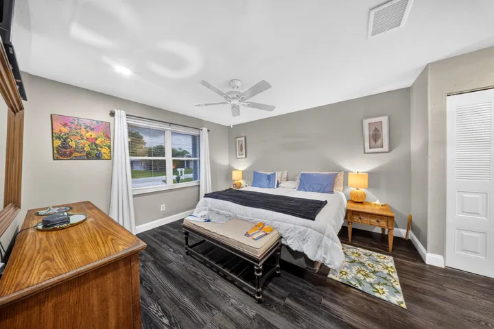Spacious room featuring wood-finish flooring, a ceiling fan, recessed lighting, a window with curtains, and a louvered bi-fold closet door