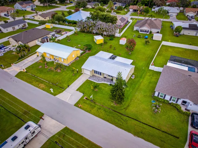 Aerial perspective showcasing multiple properties with manicured lawns and concrete driveways