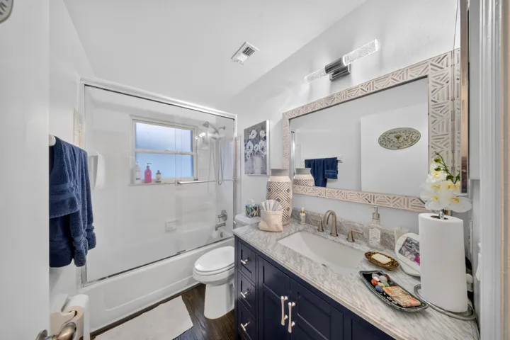 Bathroom with a dark wood-finish floor and white walls