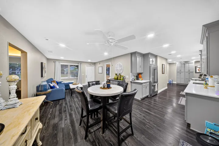 Open-concept living space featuring dark wood-finish flooring, recessed lighting, a ceiling fan, and light gray walls