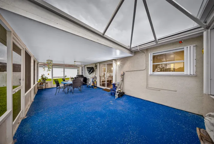 Screened patio with blue speckled flooring, a solid ceiling, and a transparent ceiling section