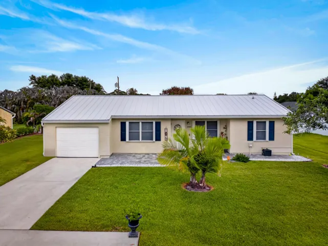 Cream-colored stucco exterior with a gray metal roof