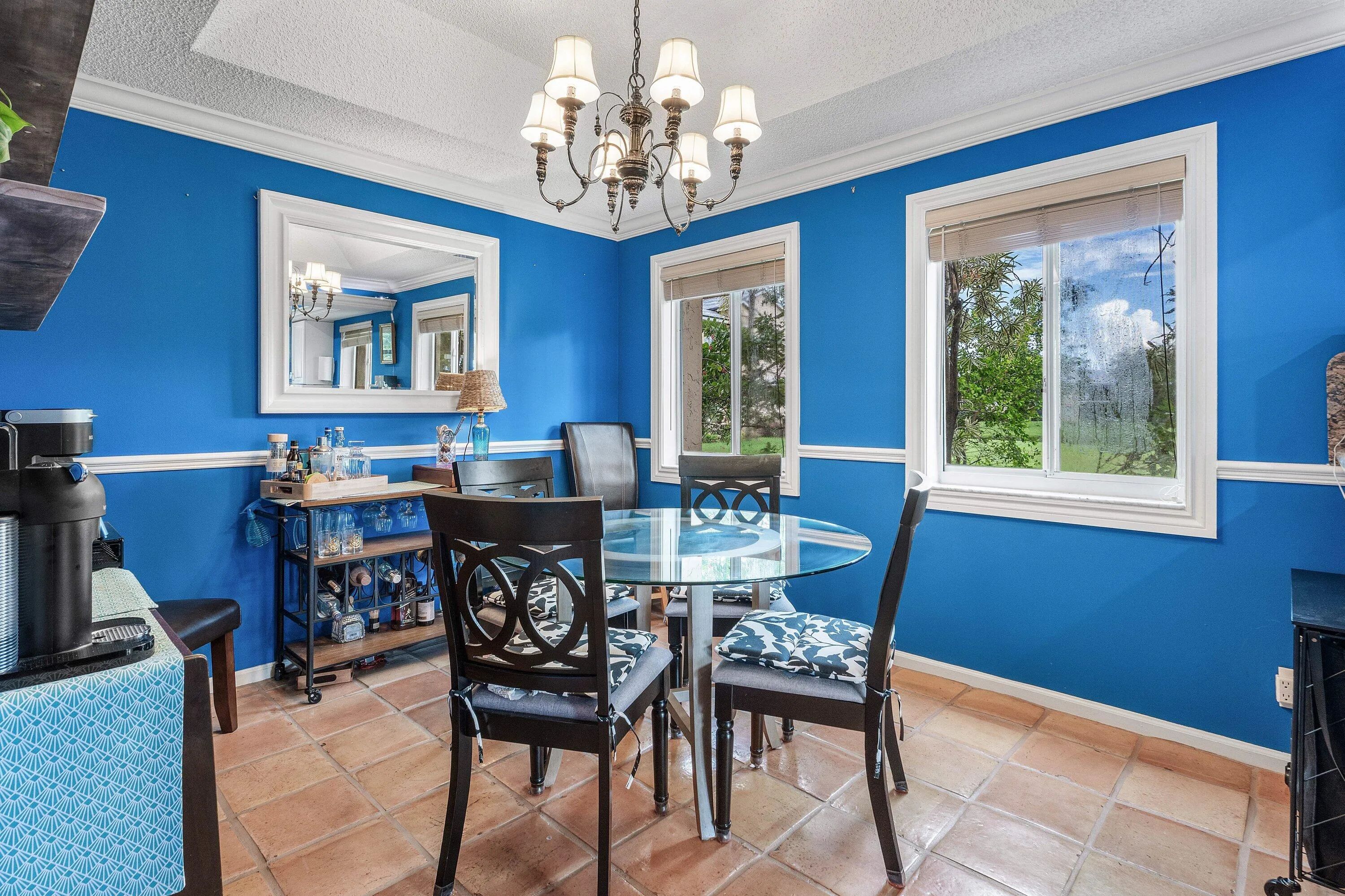 Dining area featuring terra cotta style tile flooring and a tray ceiling