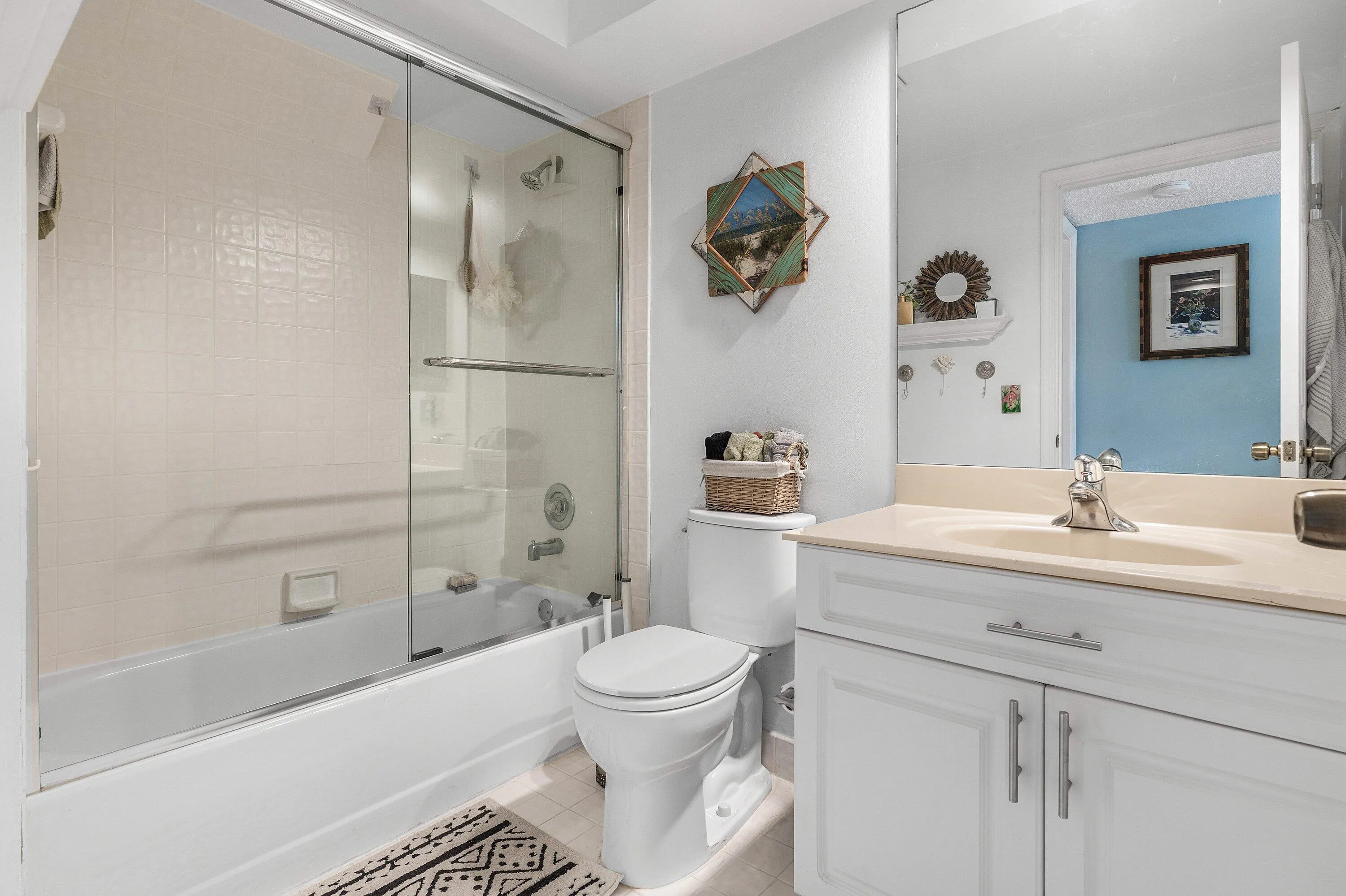 Bathroom featuring a white vanity with cabinet storage, light-colored countertop, and integrated sink