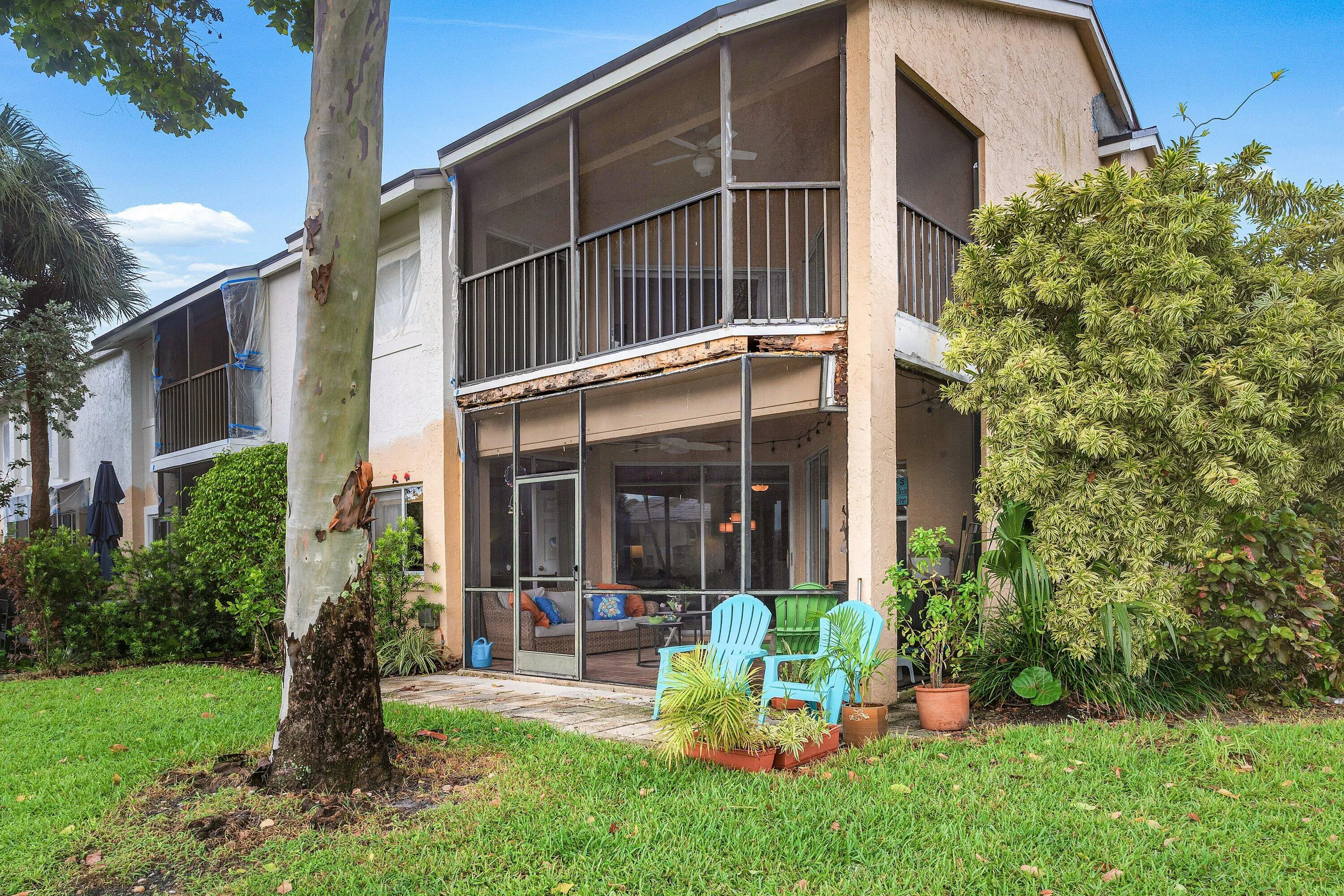 Waterfront property featuring a two-story residence with a screened patio and an upper-level screened balcony