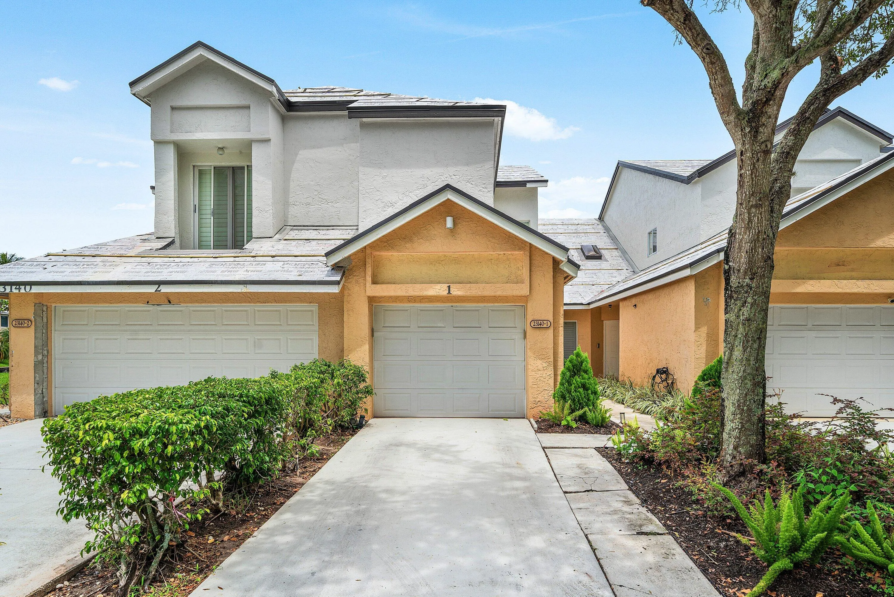 Stucco exterior featuring an attached garage with a panel​​‌​​​​‌​​‌‌​‌‌​​​‌‌​‌​‌​‌​​​‌​​ door