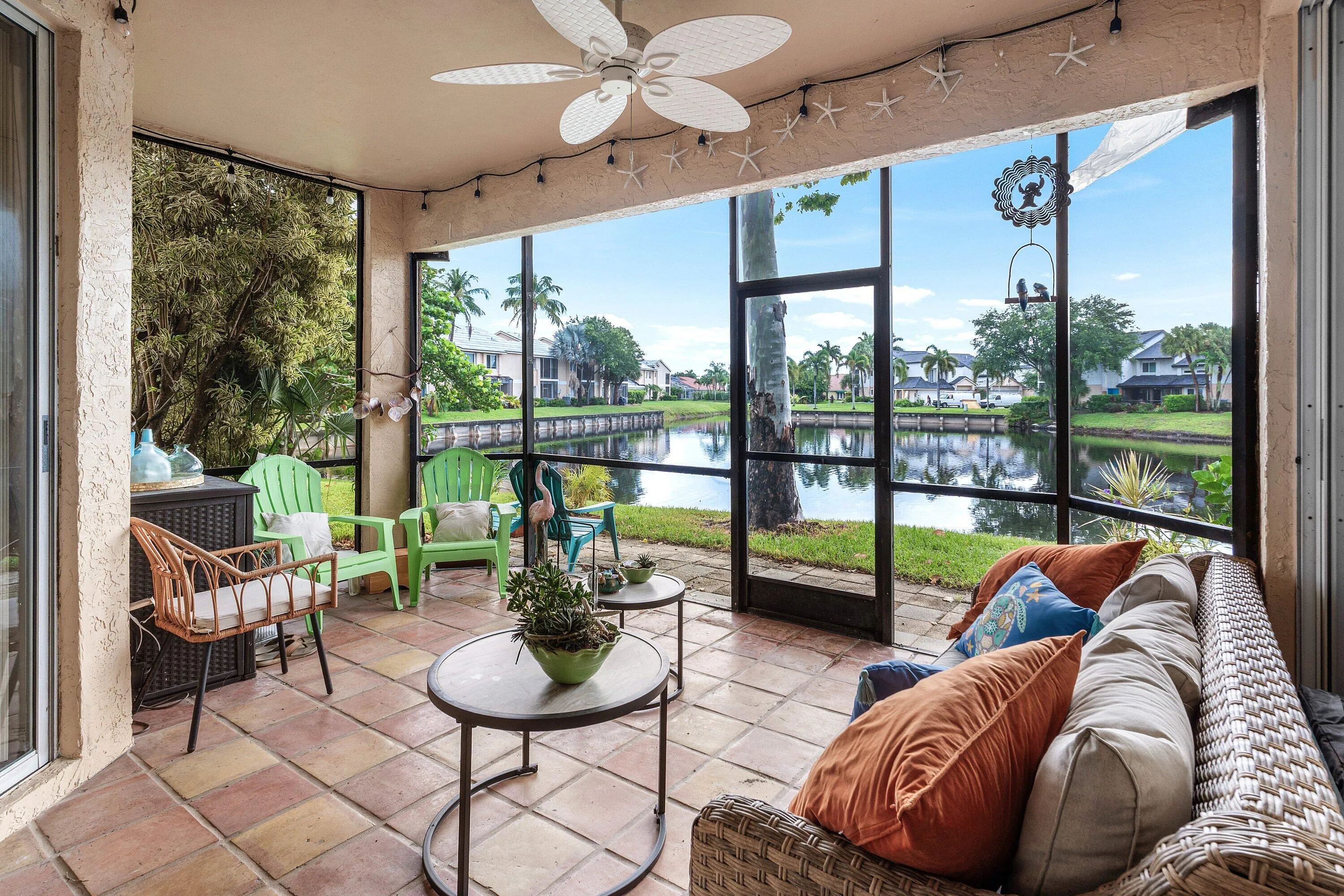 Screened patio featuring terracotta-style tile flooring and a ceiling fan