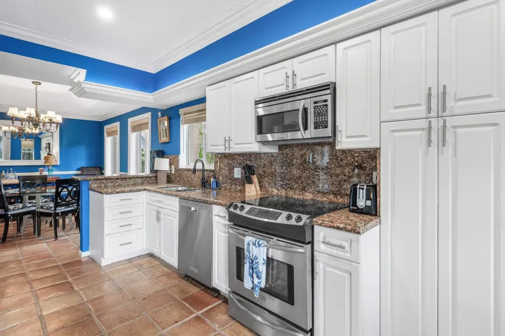 Kitchen featuring white cabinetry, granite countertops, and stainless steel appliances