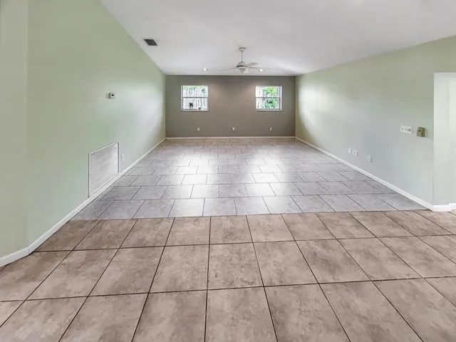 Spacious room featuring vaulted ceilings, recessed lighting, and a ceiling fan
