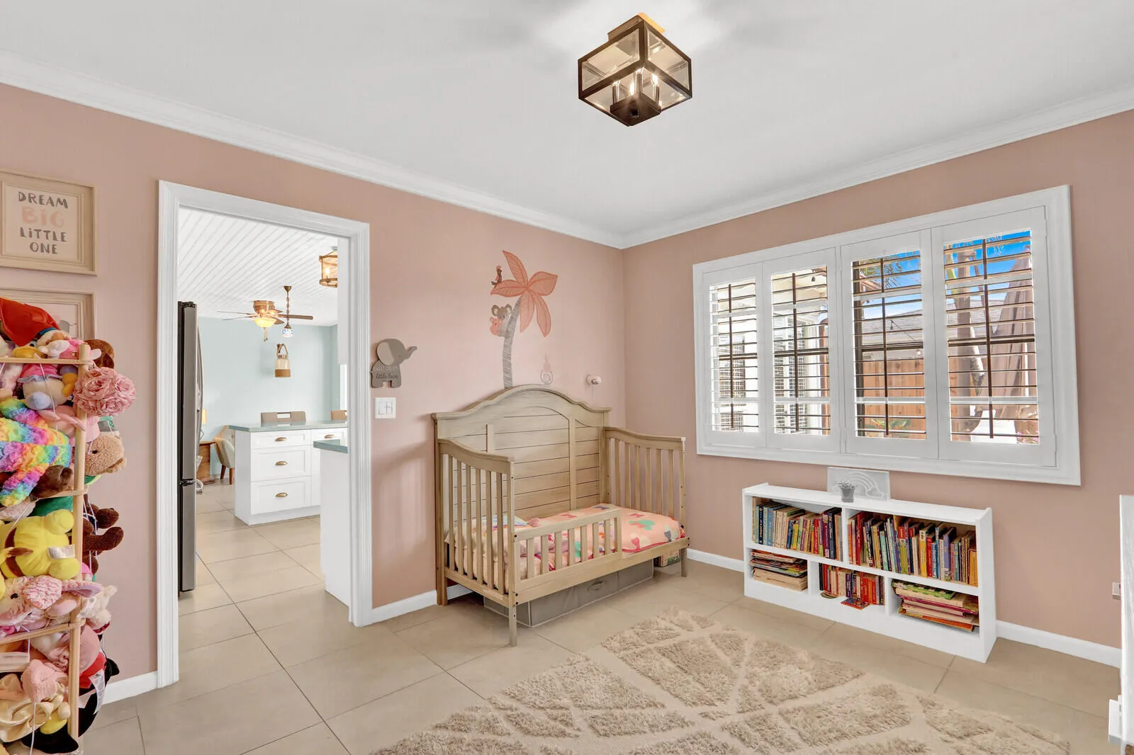 Room featuring ceramic tile flooring, crown molding, and a four-panel window with white plantation shutters