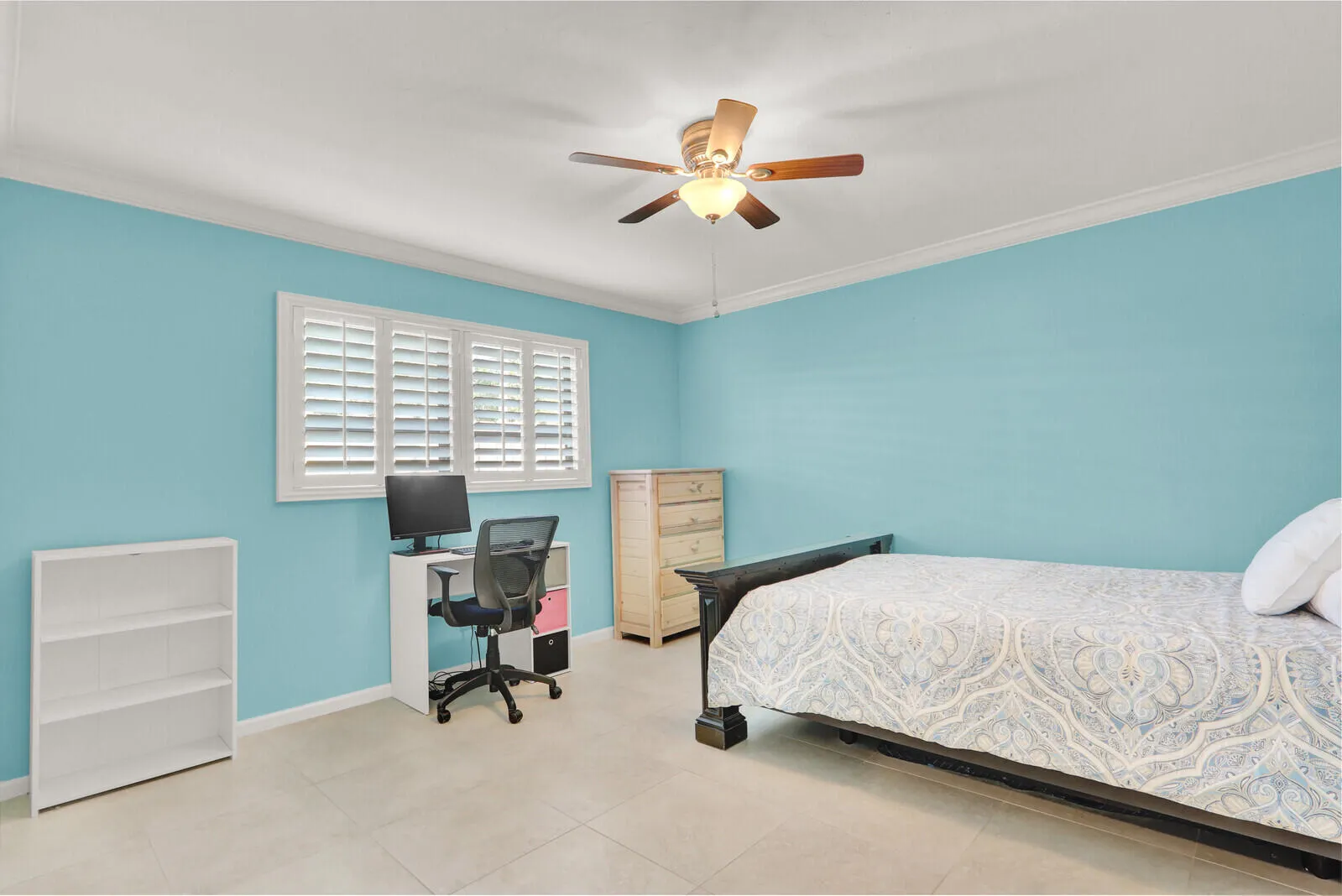 Bright room featuring a window with white plantation shutters, crown molding, and a ceiling fan with integrated lighting
