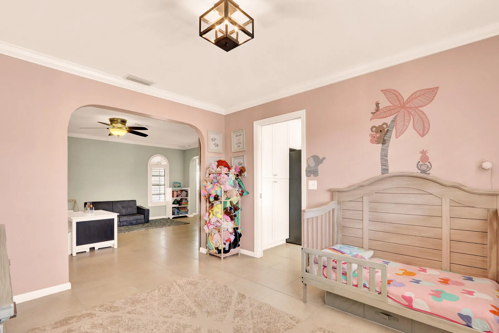 Arched entryway opens to an adjacent living area with a ceiling fan