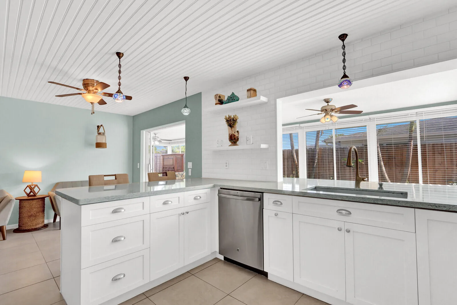 Kitchen featuring white shaker cabinetry, light-toned countertops, stainless steel appliances, and a tiled backsplash