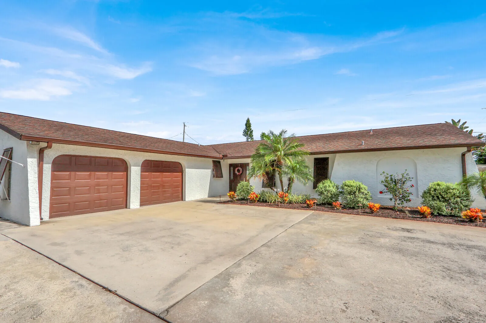 Two-car garage with arched entrances and brown panel doors