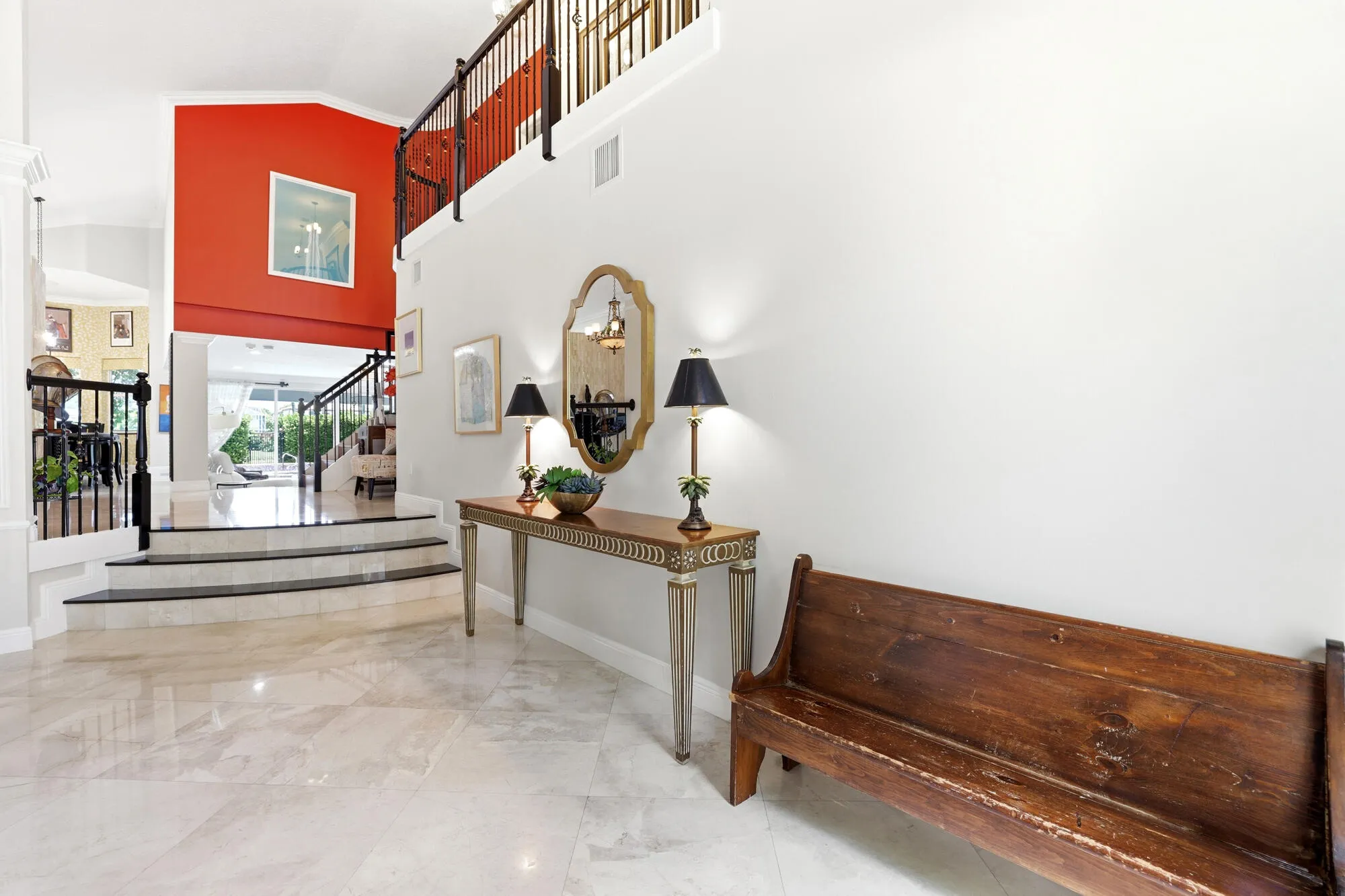 Grand entry foyer featuring polished stone flooring and a staircase with black railings